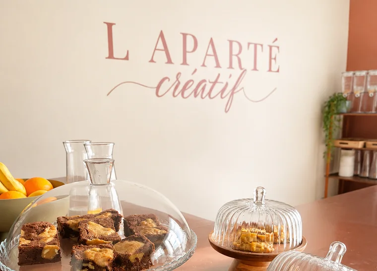 Coin gourmand de L'Aparté Créatif avec pâtisseries et logo de l'atelier